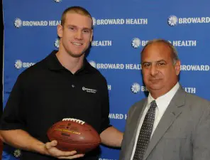 Ryan Tannehill accepts a football signed by all Broward Health orthopedic surgeons from Broward Health President/CEO Frank Nask Photo: Downtown Photo/Ryan Pinder