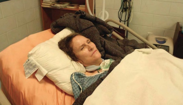 a woman lying in hospital bed on a pillow with a neck brace