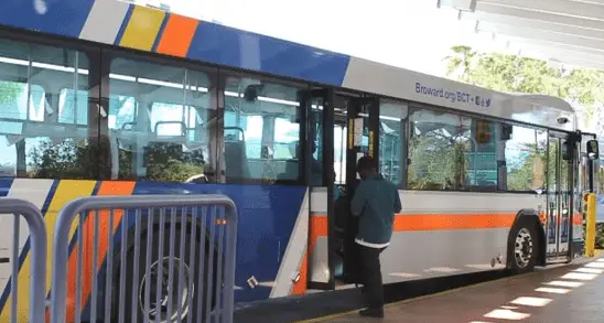 In a time of COVID-19 virus,Passenger in blue jacket enters Broward County bus via the back door.